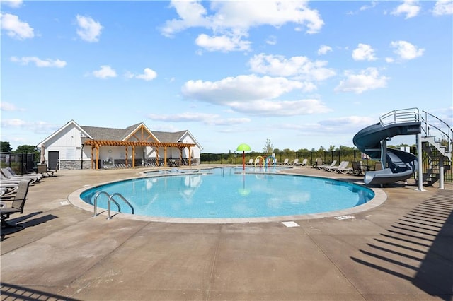 view of swimming pool with a patio area and a water slide