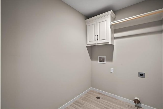 washroom featuring electric dryer hookup, cabinets, light hardwood / wood-style flooring, and washer hookup