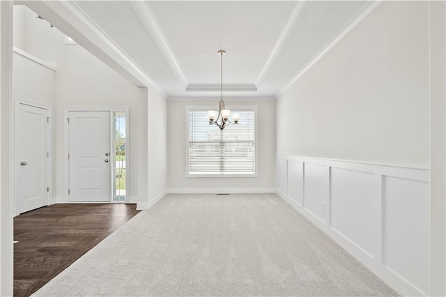 entryway with wood-type flooring, crown molding, a tray ceiling, and a chandelier