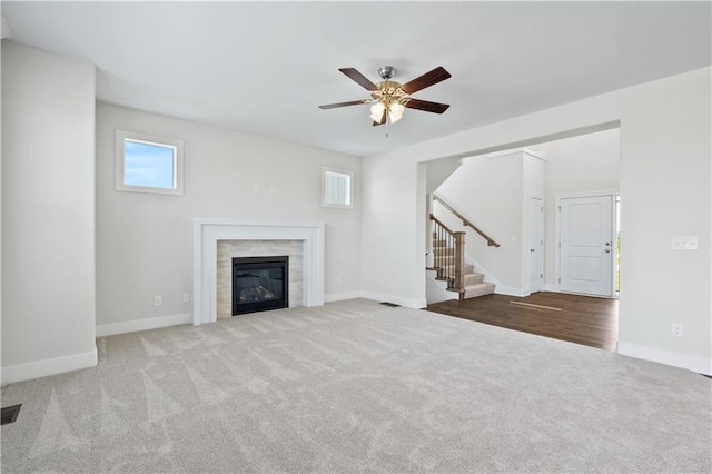 unfurnished living room featuring a fireplace, light wood-type flooring, and ceiling fan