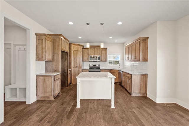 kitchen with decorative light fixtures, a center island, stainless steel appliances, and dark wood-type flooring