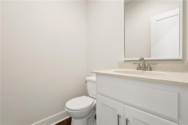 bathroom with wood-type flooring, vanity, and toilet