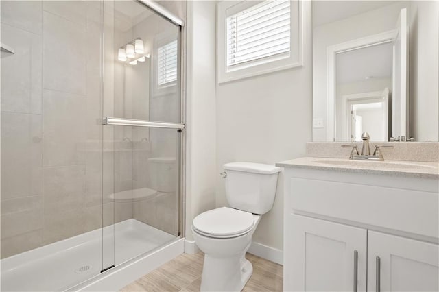 bathroom featuring wood-type flooring, vanity, toilet, and an enclosed shower