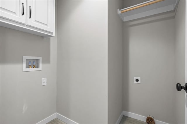 laundry area featuring hookup for a washing machine, electric dryer hookup, cabinets, and light hardwood / wood-style floors