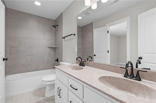 full bathroom featuring vanity, tiled shower / bath combo, and toilet