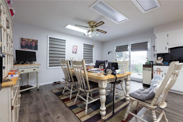 dining area featuring ceiling fan, dark wood-type flooring, and a textured ceiling