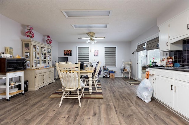 dining room featuring ceiling fan, dark wood-type flooring, and a textured ceiling