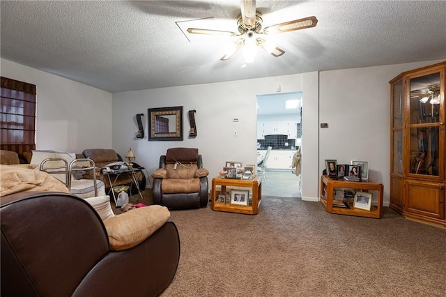 living room with carpet, ceiling fan, and a textured ceiling