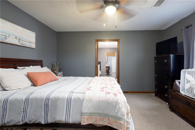 carpeted bedroom with ceiling fan and a textured ceiling