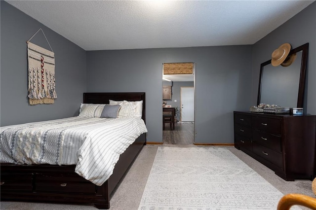 bedroom with a textured ceiling and light colored carpet