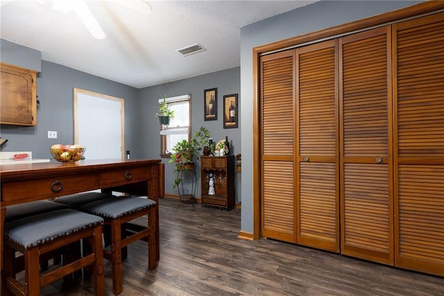 dining space featuring a textured ceiling and dark hardwood / wood-style flooring