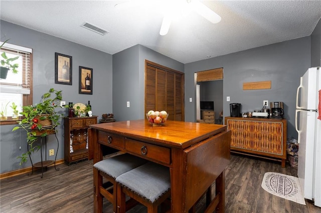 interior space featuring ceiling fan, dark hardwood / wood-style flooring, white fridge, and a textured ceiling