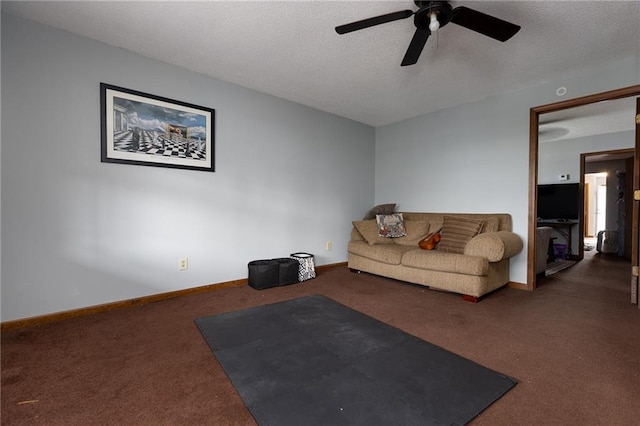 living room with a textured ceiling, dark colored carpet, and ceiling fan