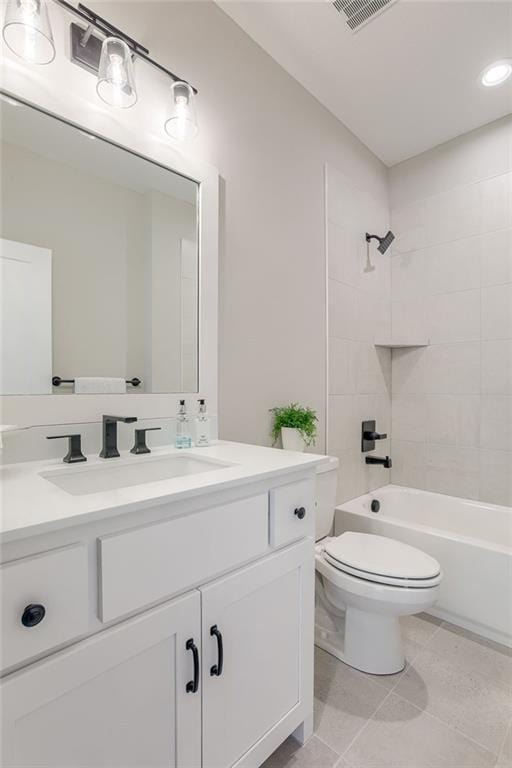 full bathroom with tiled shower / bath combo, vanity, tile patterned flooring, and toilet