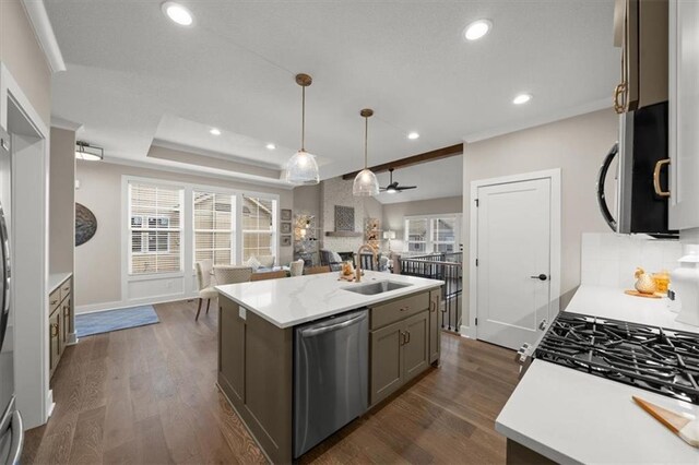 kitchen featuring pendant lighting, an island with sink, stainless steel dishwasher, and dark hardwood / wood-style floors