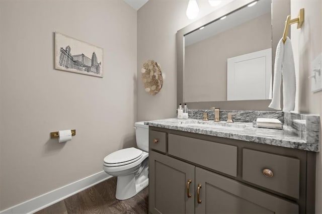 bathroom with wood-type flooring, vanity, and toilet