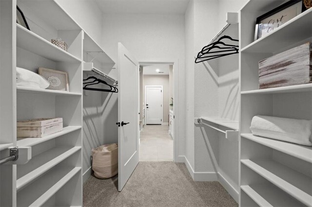 walk in closet featuring light colored carpet