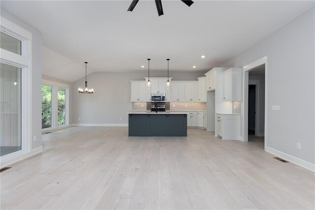 kitchen featuring lofted ceiling, white cabinetry, and light hardwood / wood-style floors