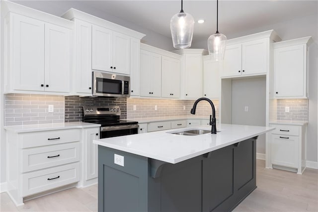 kitchen with backsplash, a kitchen island with sink, stainless steel appliances, and sink