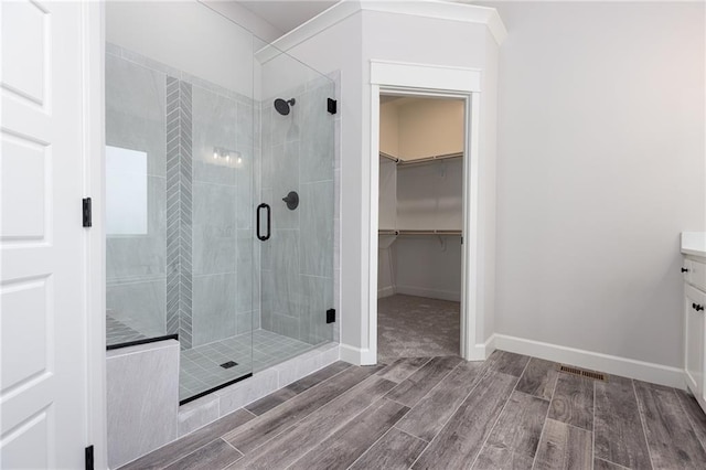 bathroom featuring vanity, walk in shower, and hardwood / wood-style floors