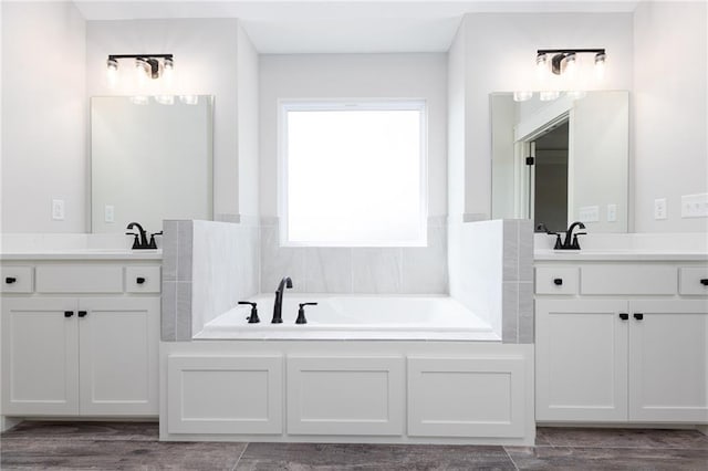 bathroom with double vanity and a bathing tub