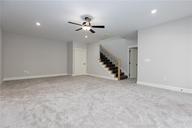 spare room with ceiling fan and light colored carpet