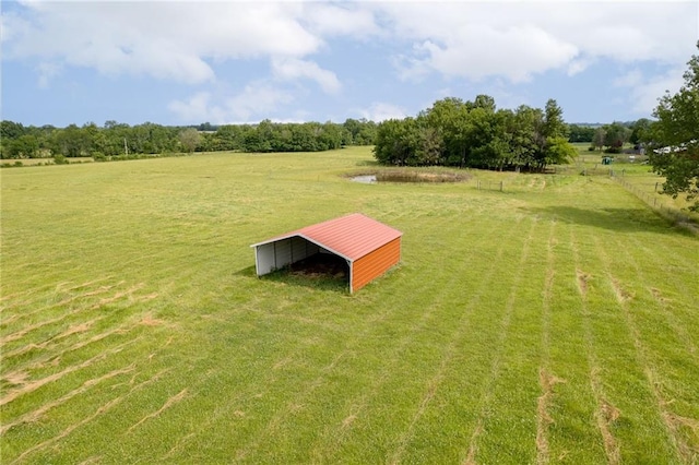 view of yard featuring a rural view and an outdoor structure