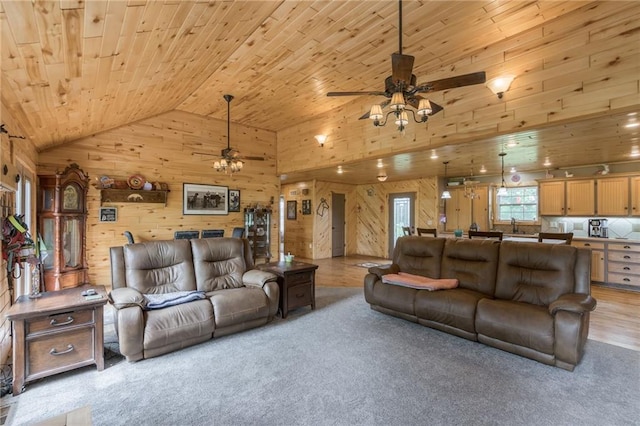 carpeted living room with wood ceiling, ceiling fan, sink, high vaulted ceiling, and wood walls