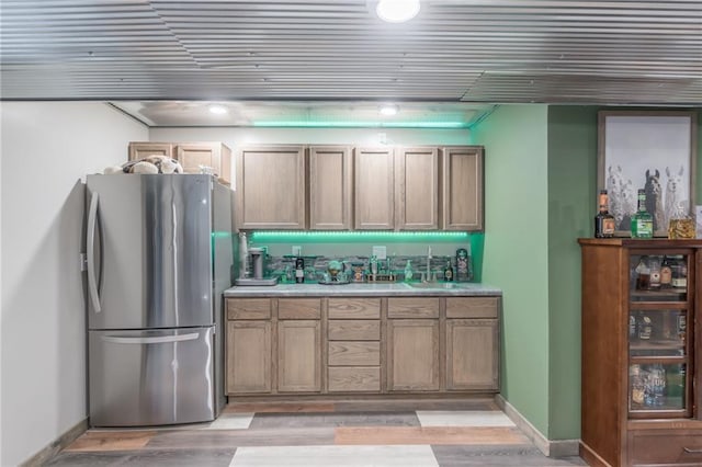 kitchen featuring light hardwood / wood-style floors, stainless steel refrigerator, and sink