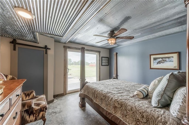 bedroom featuring access to exterior, a barn door, and ceiling fan