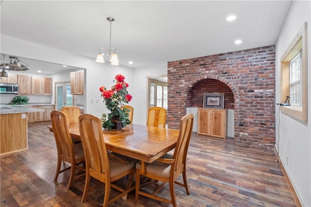 dining space with dark wood-type flooring and a chandelier