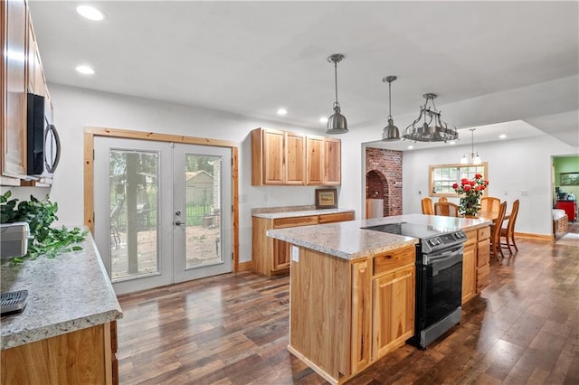 kitchen featuring french doors, stainless steel range with electric cooktop, a center island, dark hardwood / wood-style floors, and pendant lighting