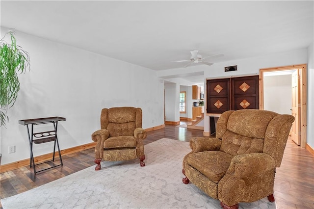 living area featuring hardwood / wood-style flooring and ceiling fan