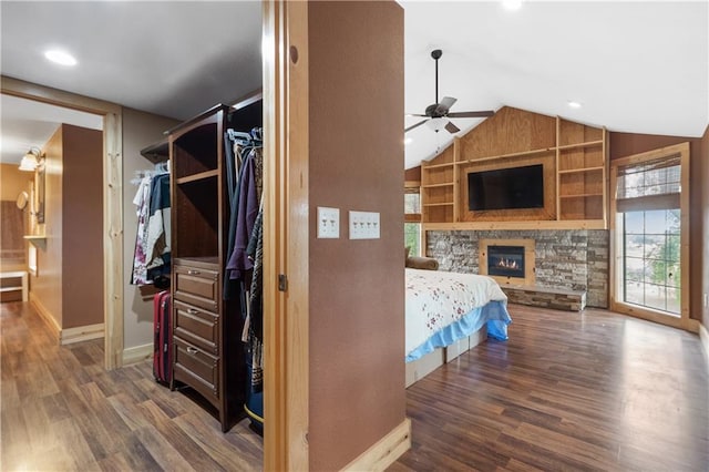 bedroom with dark hardwood / wood-style flooring, a fireplace, and vaulted ceiling