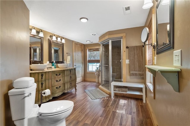 bathroom with a shower with door, vanity, hardwood / wood-style flooring, and toilet