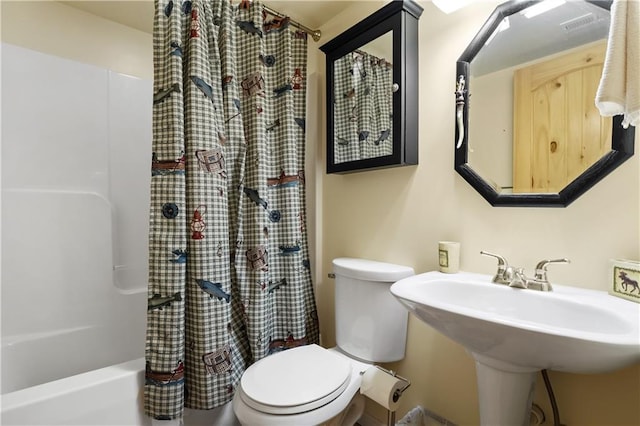 full bathroom with sink, shower / bath combination with curtain, and toilet