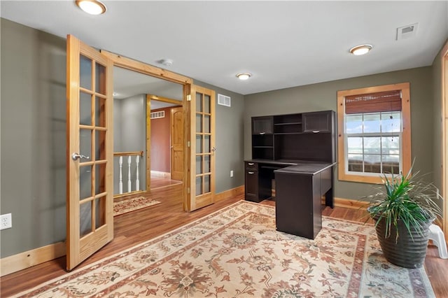 office area with light wood-type flooring and french doors