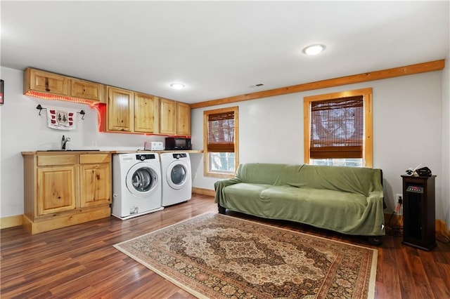 laundry area with cabinets, independent washer and dryer, dark hardwood / wood-style floors, and sink