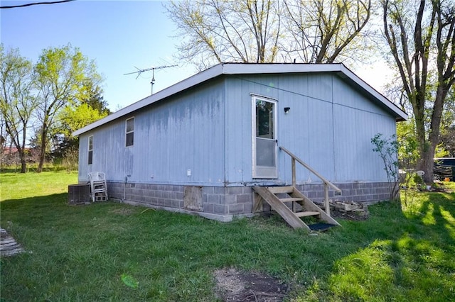 exterior space with central air condition unit and a lawn