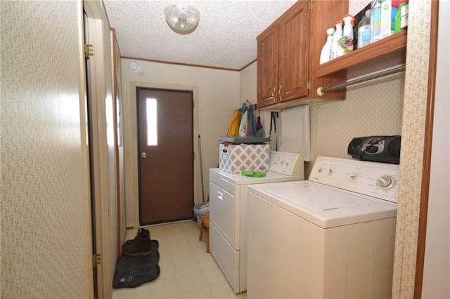 clothes washing area with washer and clothes dryer, a textured ceiling, cabinets, and light tile floors