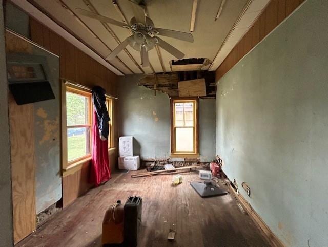 miscellaneous room featuring wood-type flooring, ceiling fan, and wood walls