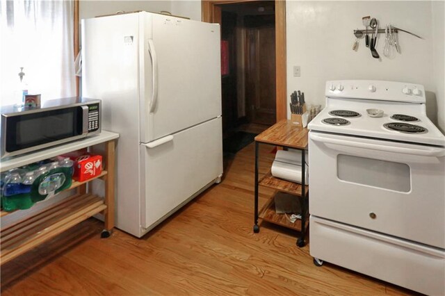 kitchen featuring hardwood / wood-style floors and white appliances