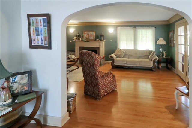 living room featuring ornamental molding and wood-type flooring