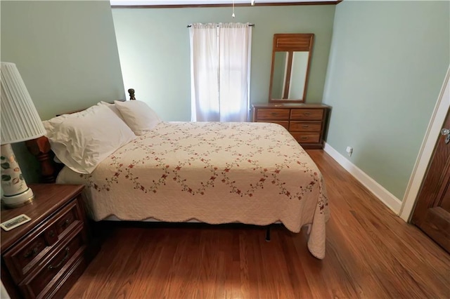 bedroom featuring dark wood-style floors and baseboards