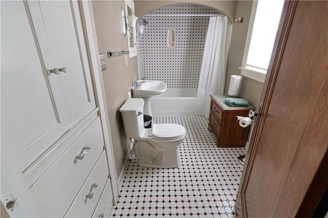 full bathroom with shower / bath combo with shower curtain, sink, toilet, and tile patterned floors