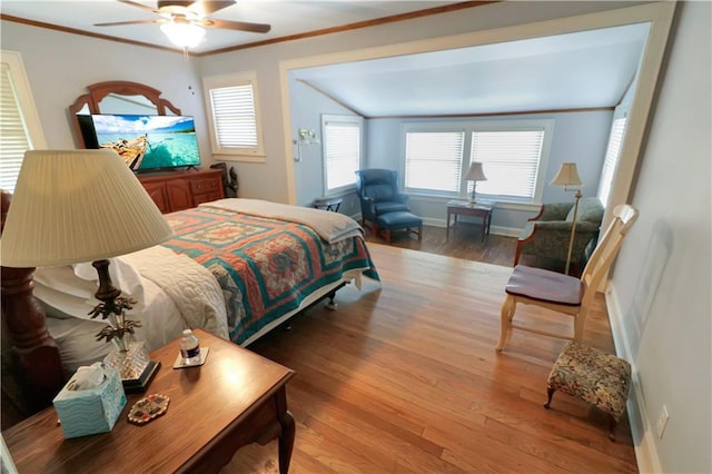 bedroom featuring crown molding, a ceiling fan, vaulted ceiling, wood finished floors, and baseboards