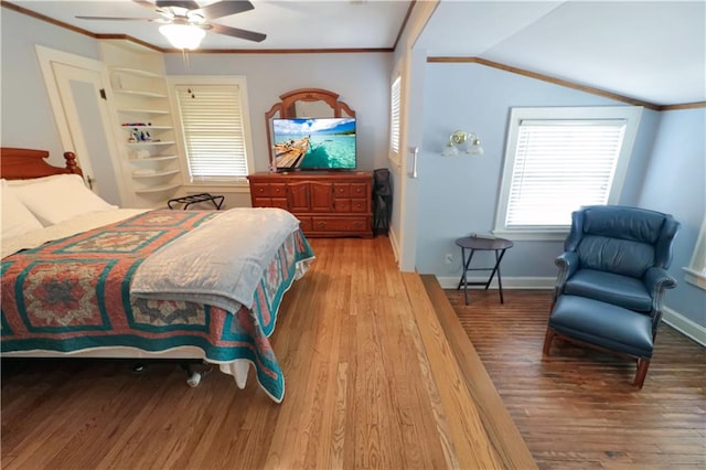 bedroom with lofted ceiling, hardwood / wood-style flooring, crown molding, and ceiling fan