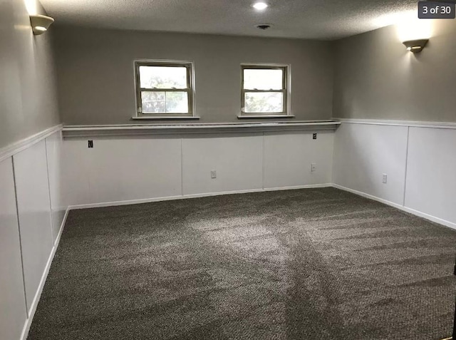 unfurnished room featuring carpet flooring and a textured ceiling