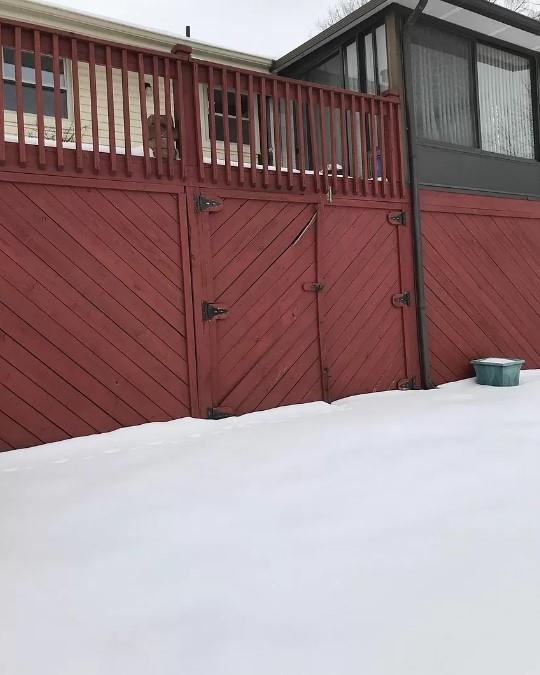 snow covered gate with an outbuilding