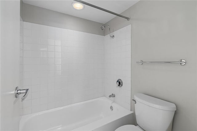 bathroom featuring toilet and tiled shower / bath